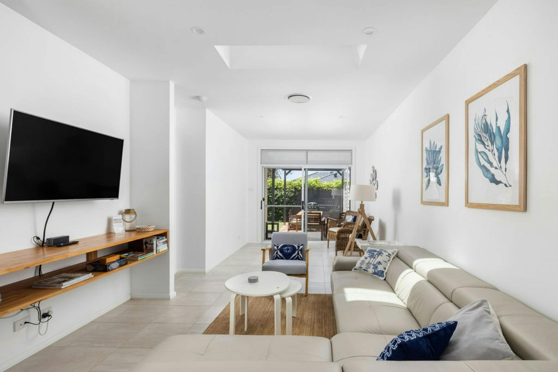 Open plan living area with leather lounge, leading to an enclosed courtyard