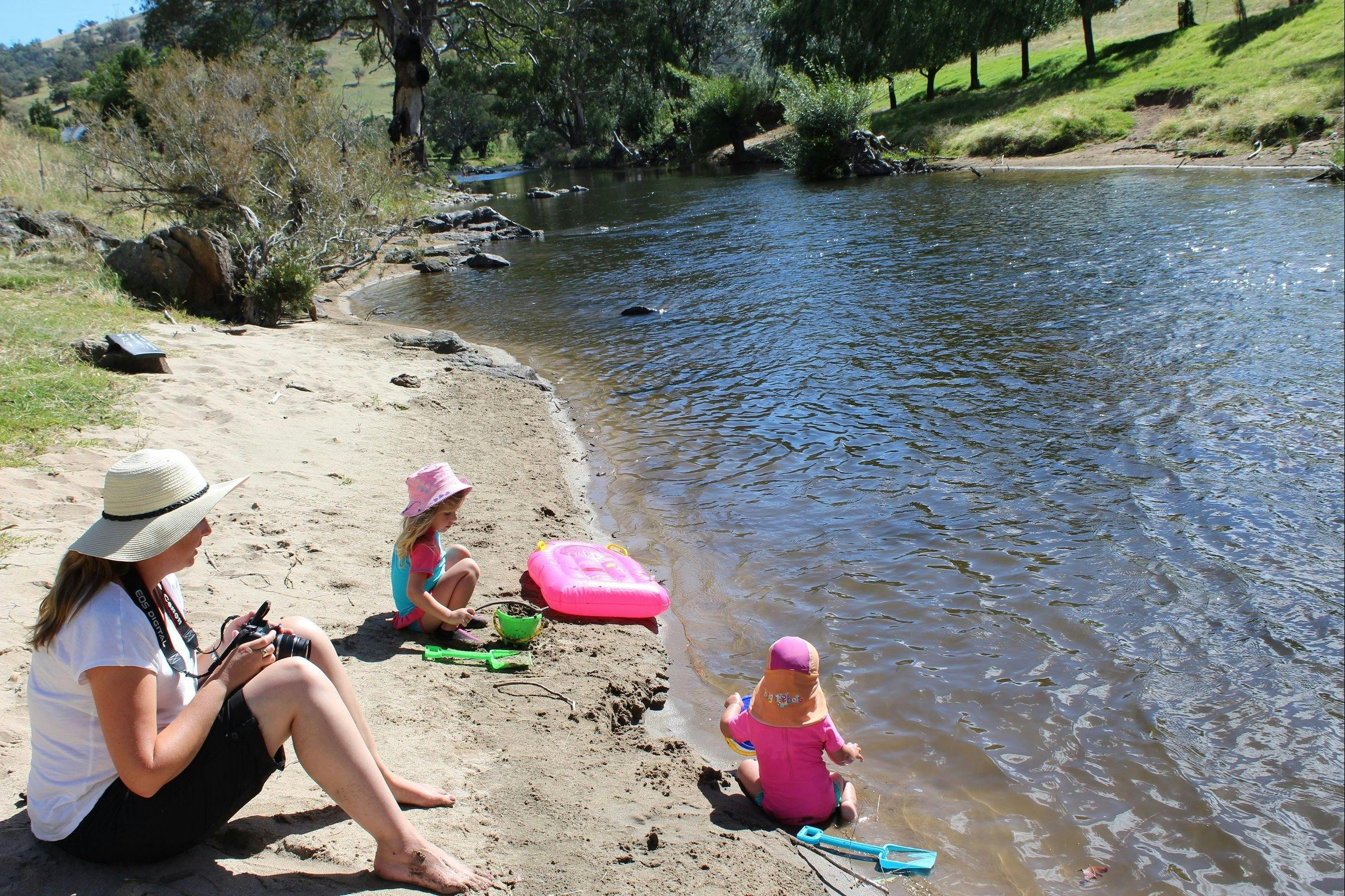 Family enjoying a swim at our sandy river beach
