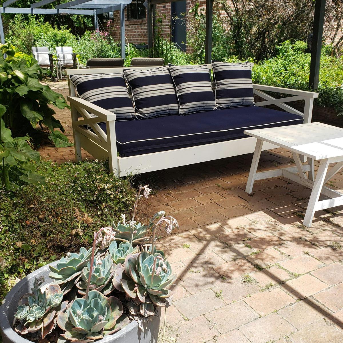 Sofa bed in private outdoor area beaneath the pergola