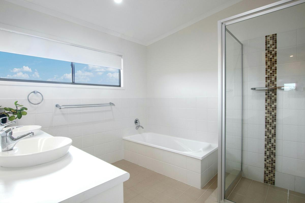 Family-friendly bathroom with dual sinks, spacious tub, and shower. Plus, an additional bathroom.