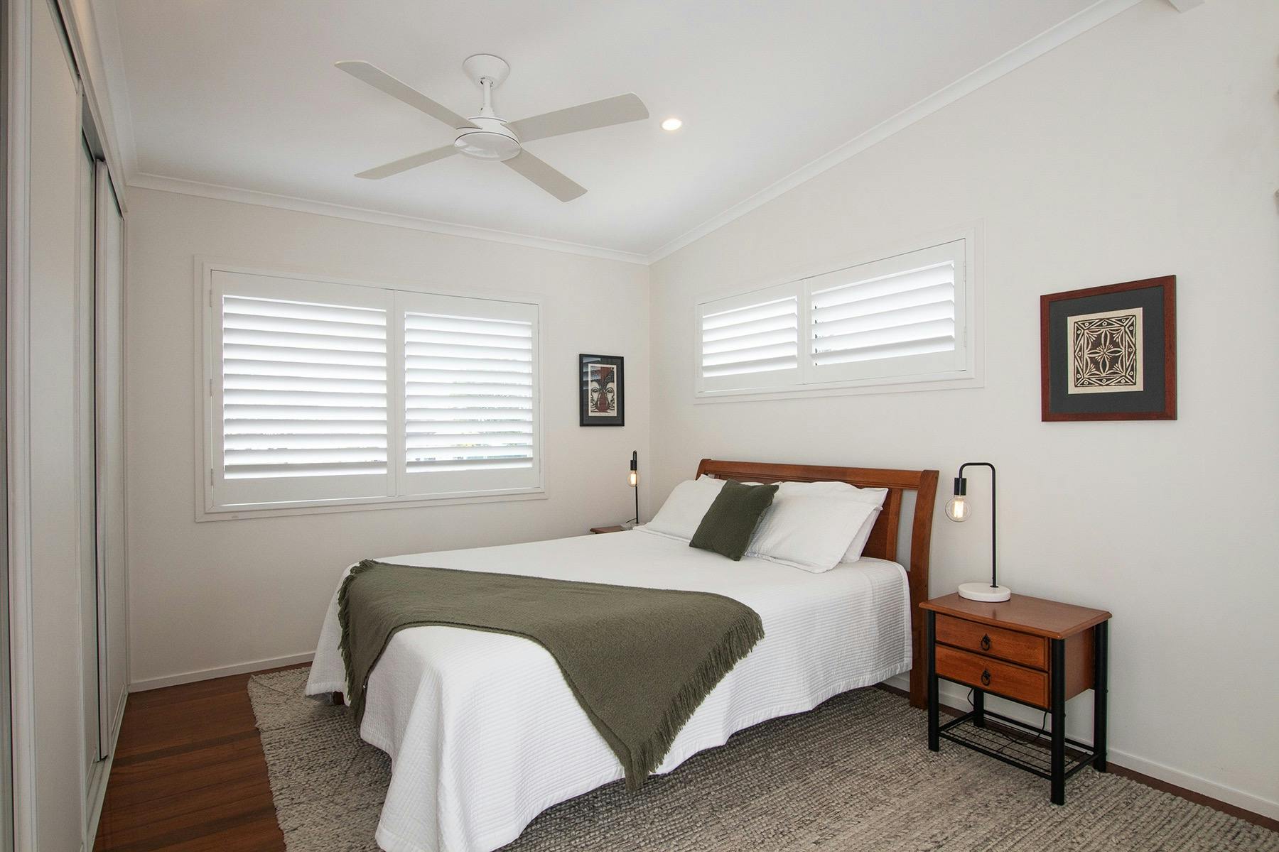 Large bedroom with queen size bed, sofa and balcony with views