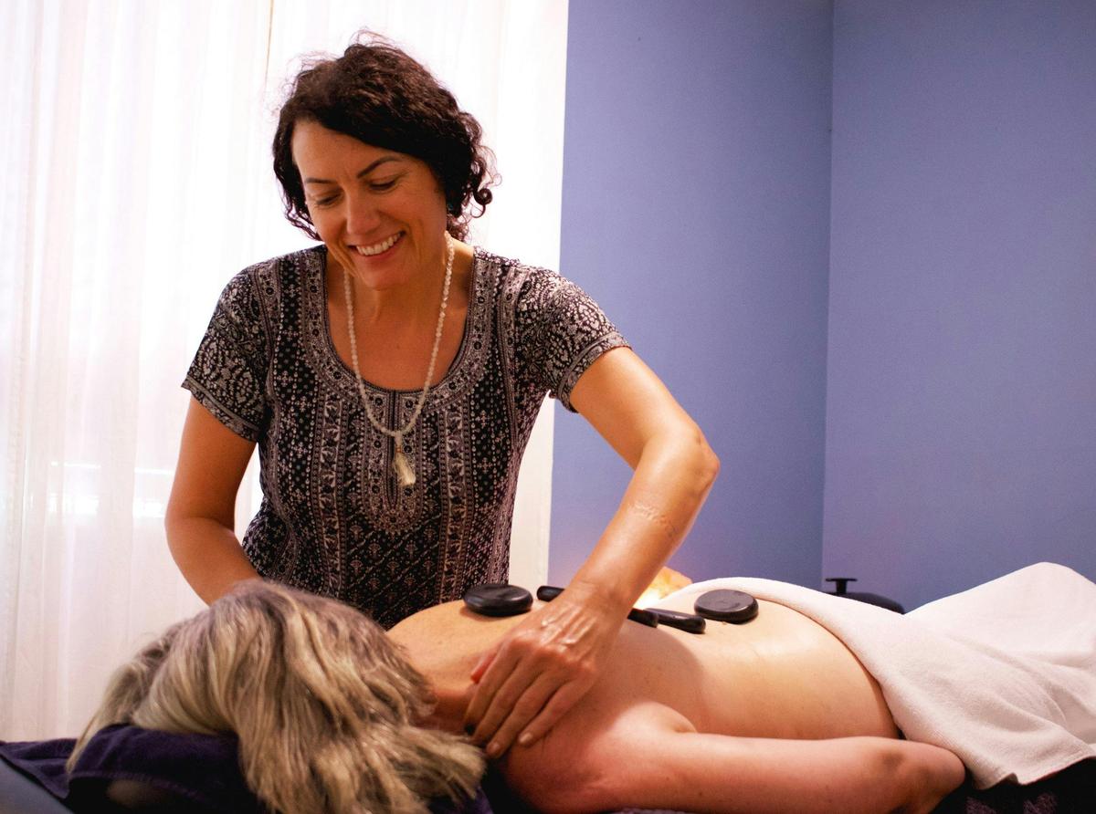 Masseuse giving hot stone massage