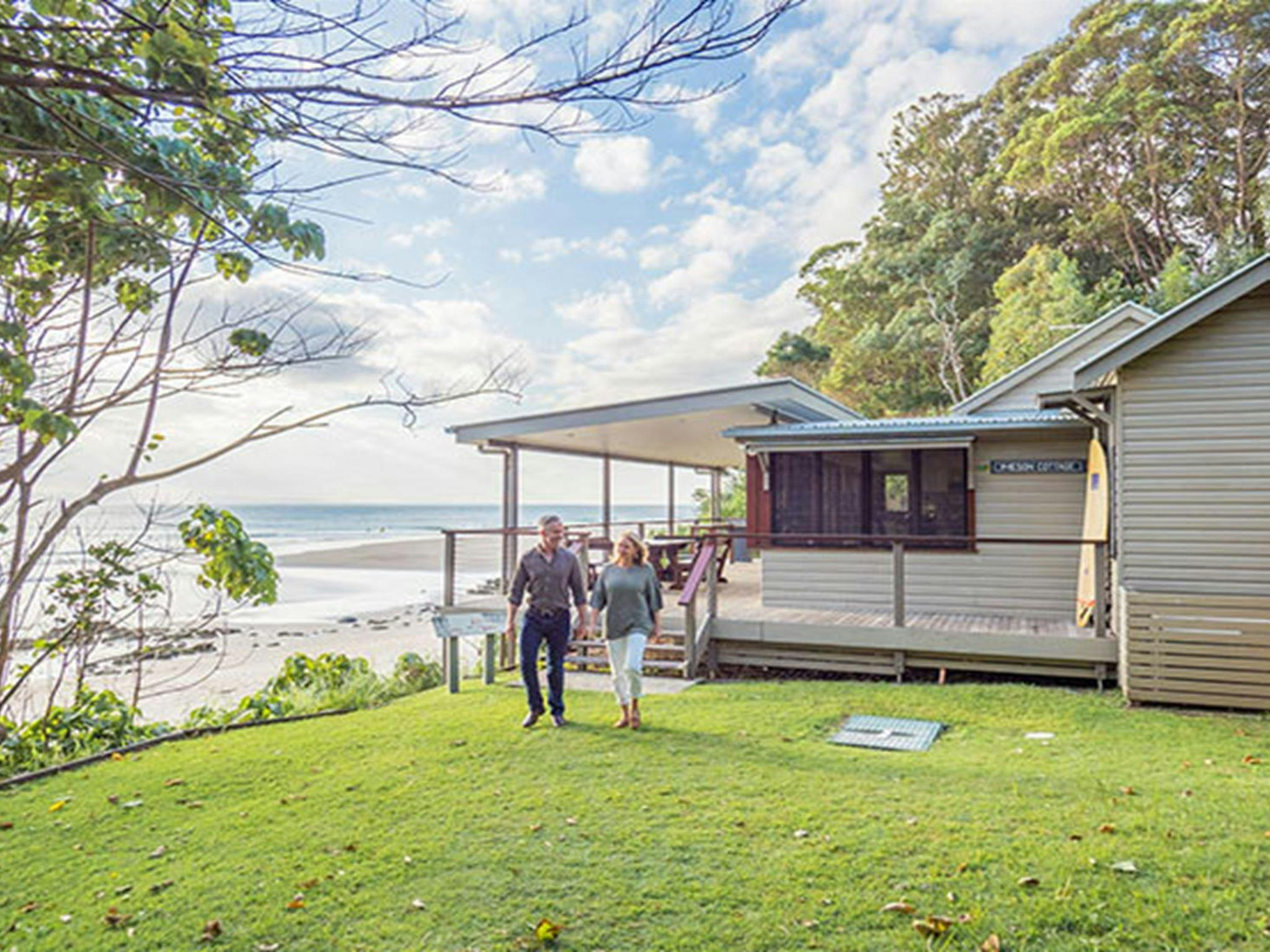 Couple walking on the lawn at Imeson Cottage. Photo: Sera Wright/DPIE.