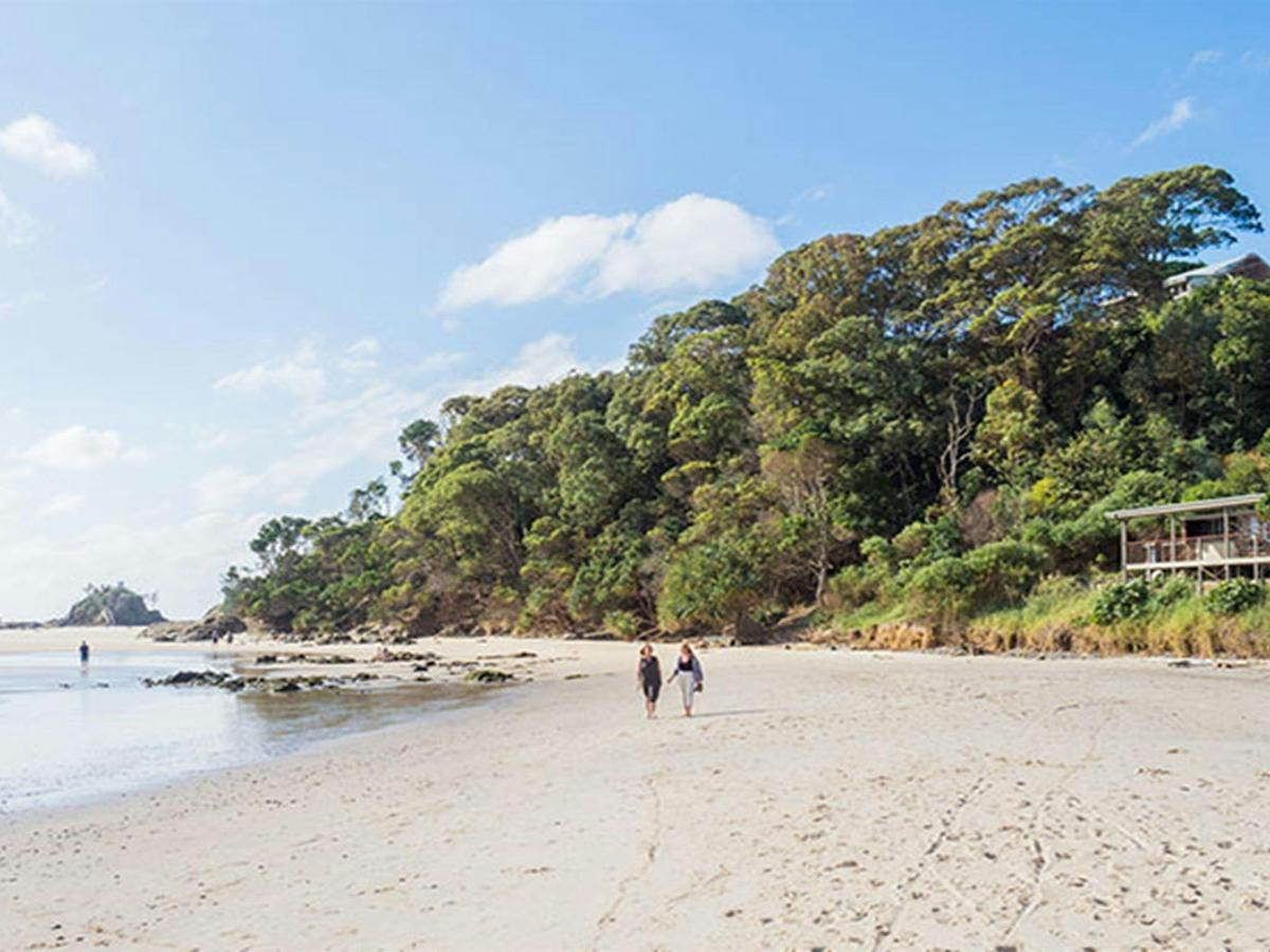 Friends walking on the beach in front of Imeson Cottage. Photo: Sera Wright/DPIE.