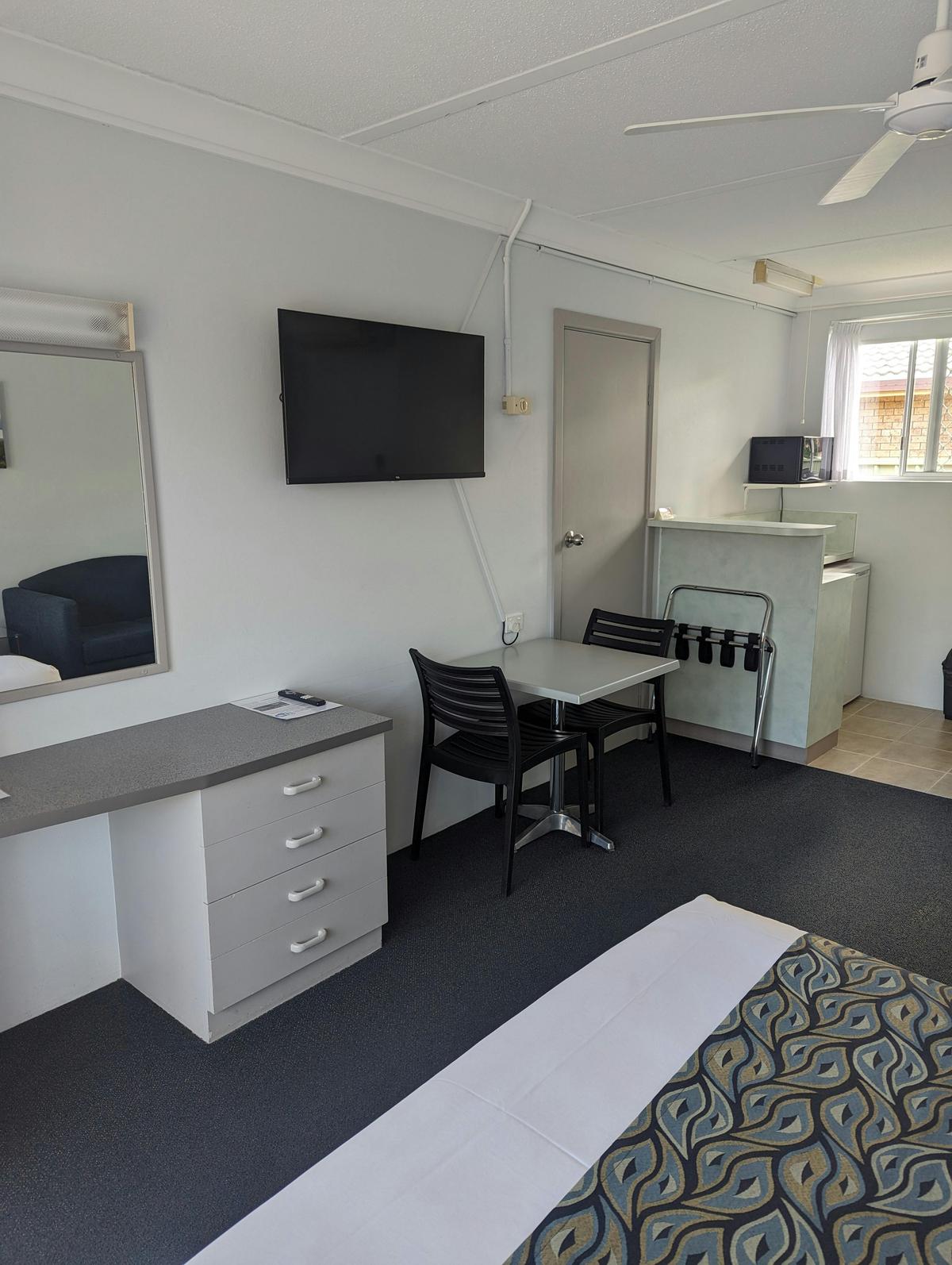 Queen motel room TV and dining area