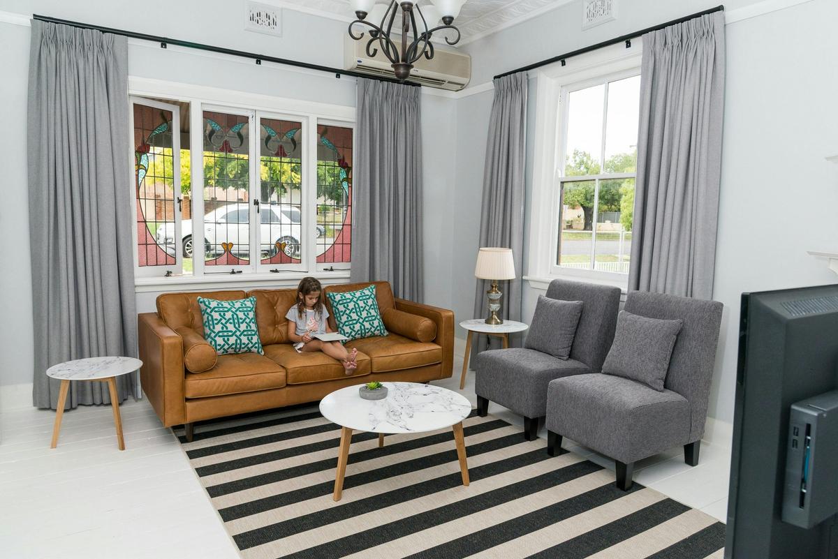 Kirsten Accommodation Parkes Deluxe Cottage Lounge room boasting stain glass windows and press metai