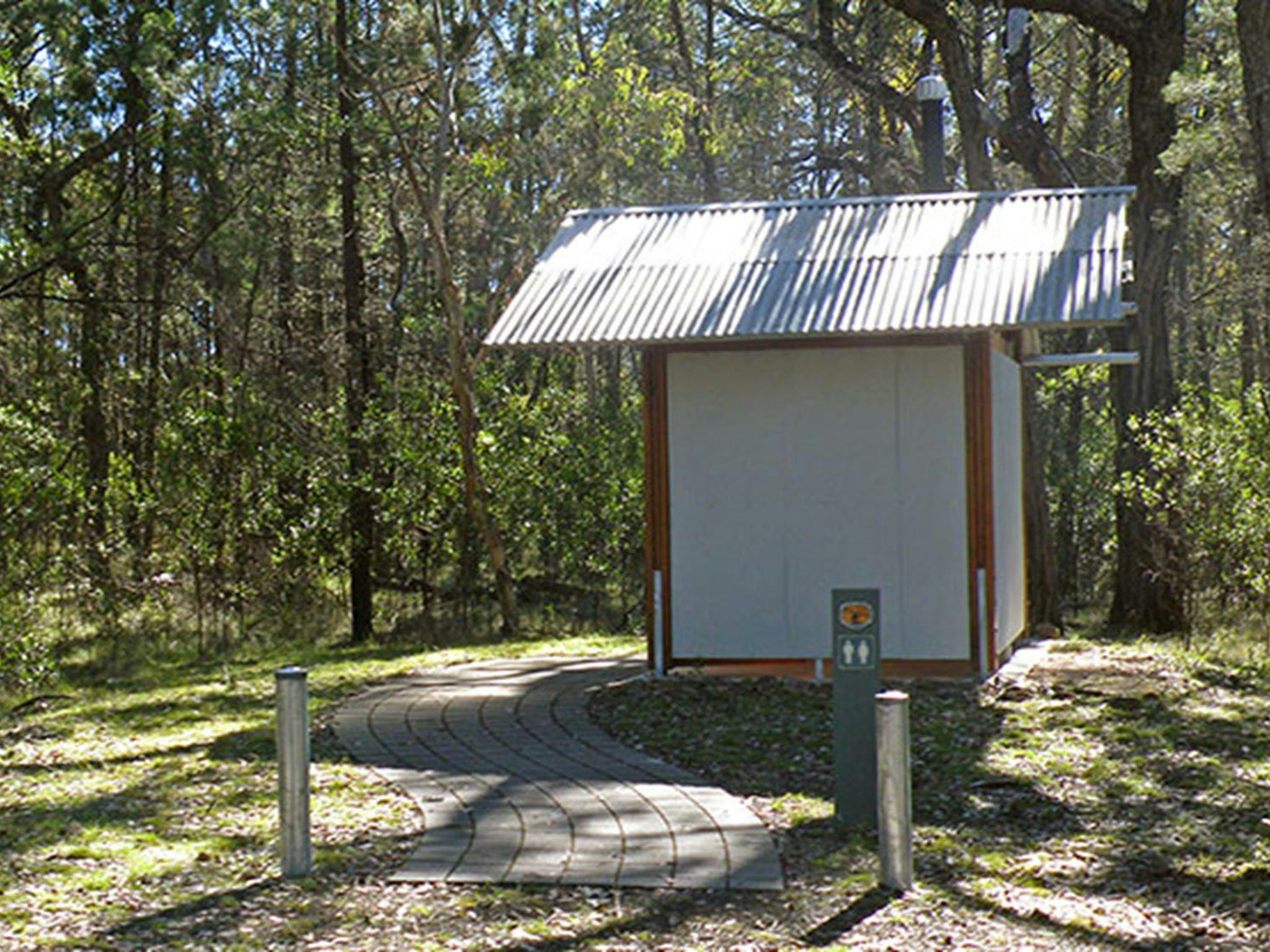 View of paved path to toilet facilities surrounded by bushland, in Horton Falls National Park.