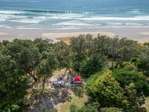 Aerial view of a tent campsite set back from the ocean at Illaroo campground. Credit: John Spencer
