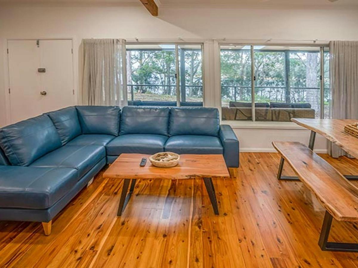 Judges House living room, with couch, coffee table and dining table with bench, Murramarang National