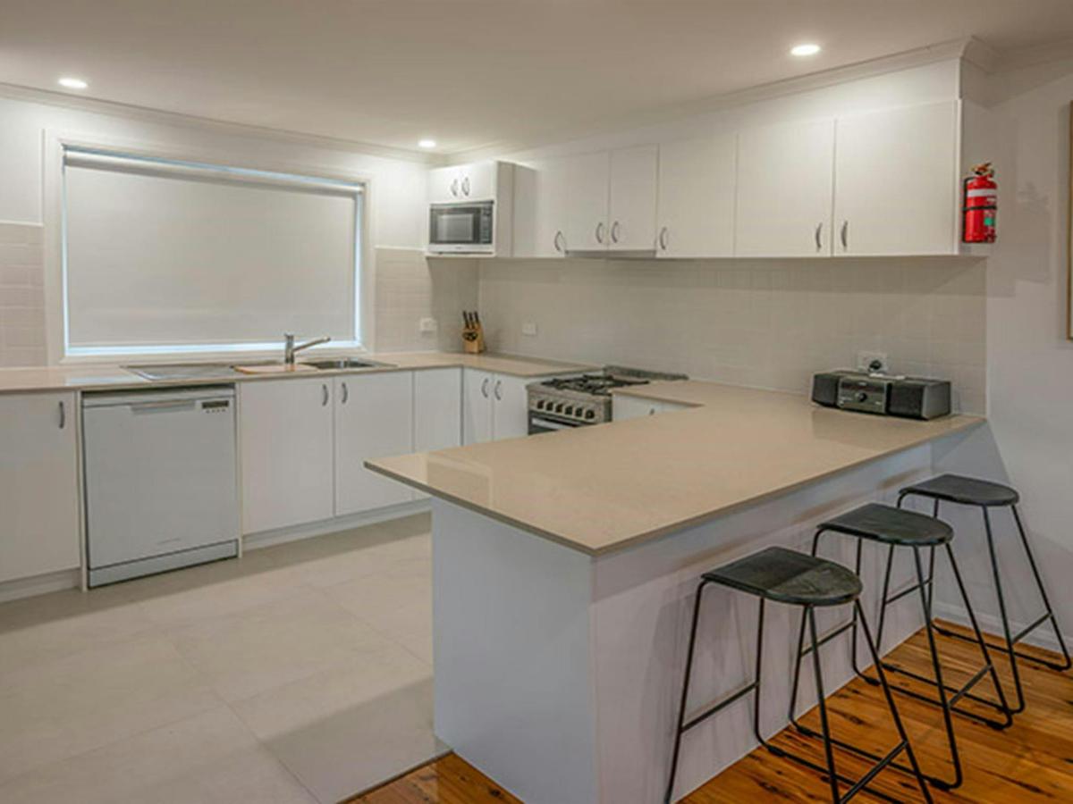 Judges House kitchen with modern appliances, bench and bar stools, Murramarang National Park. Photo: