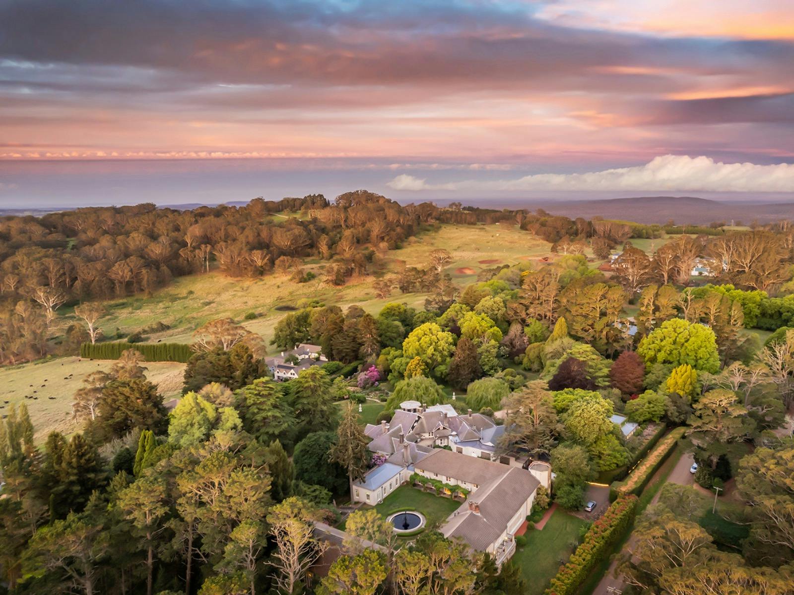An aerial view of Milton Park at dusk surrounded by rolling hills and colourful trees.