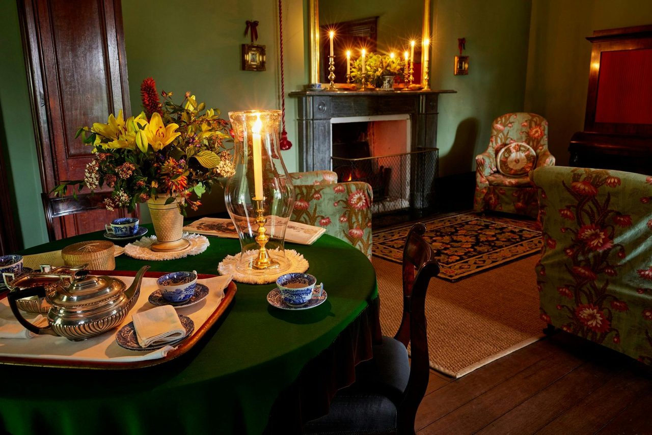 Historic living room with dining set up and candles lit