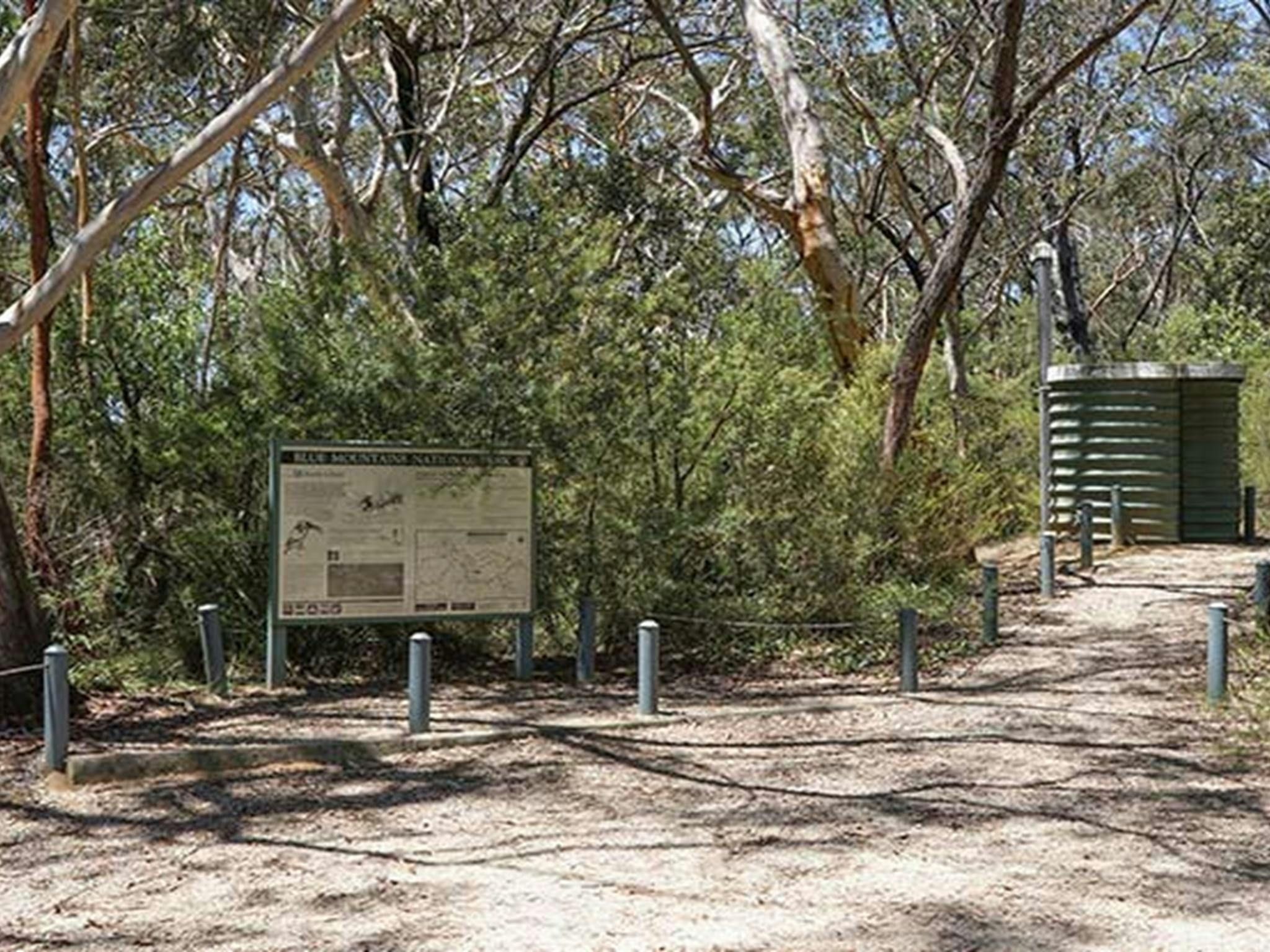 Gravel path past sign to non-flush toilet, Ingar campground, Blue Mountains National Park. Photo: