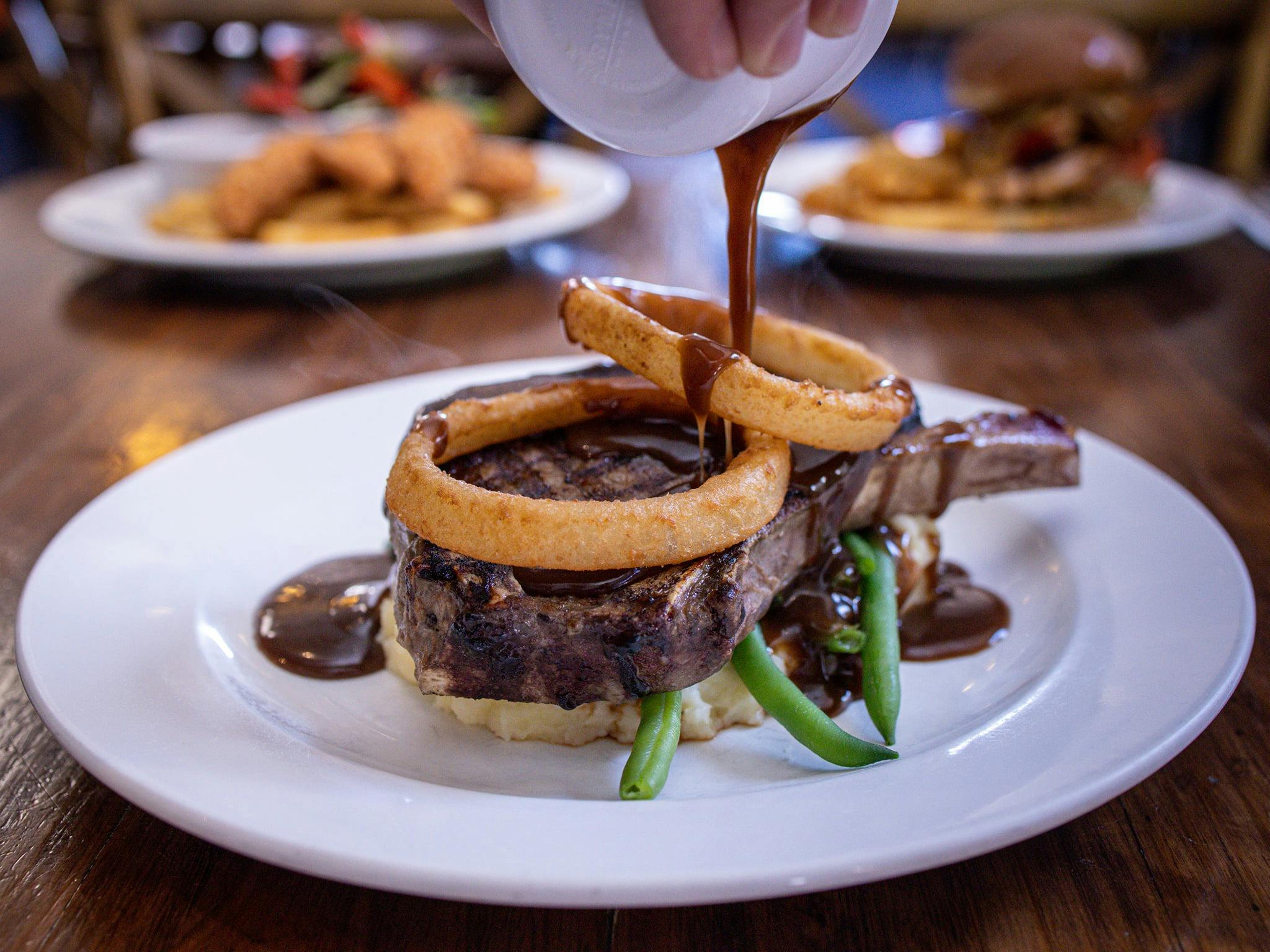 350g Ribeye steak over mashed potatoes and green beans.