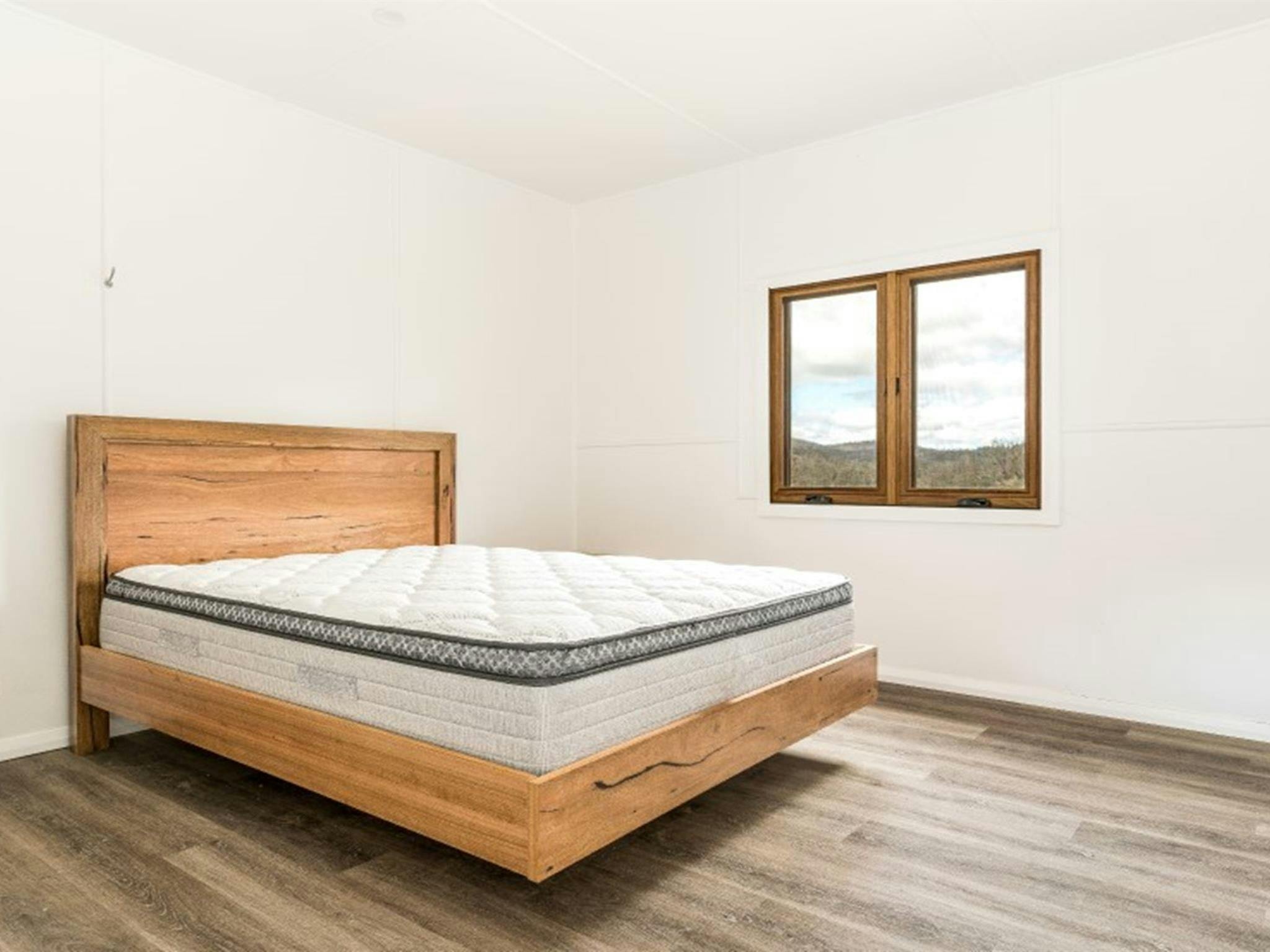 A bedroom with queen bed at Mooraback Cabin in Werrikimbe National Park. Photo: David Waugh &copy;