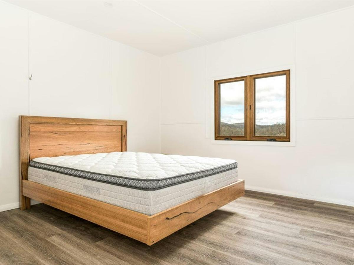A bedroom with queen bed at Mooraback Cabin in Werrikimbe National Park. Photo: David Waugh &copy;