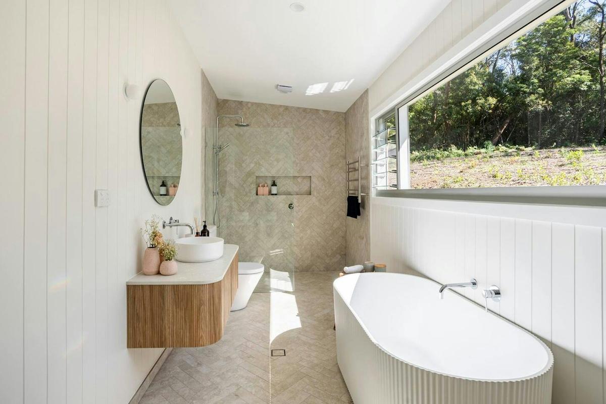 Bathroom with bath and forest view