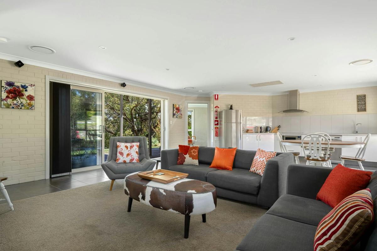 Large lounge area looking towards the kitchen, second bedroom and outdoor patio and BBQ area
