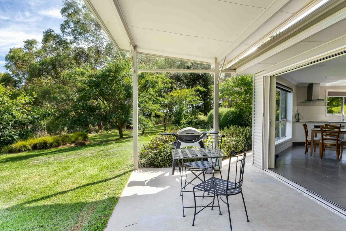 Patio with outdoor dining furniture and looking to garden and inside to dining area