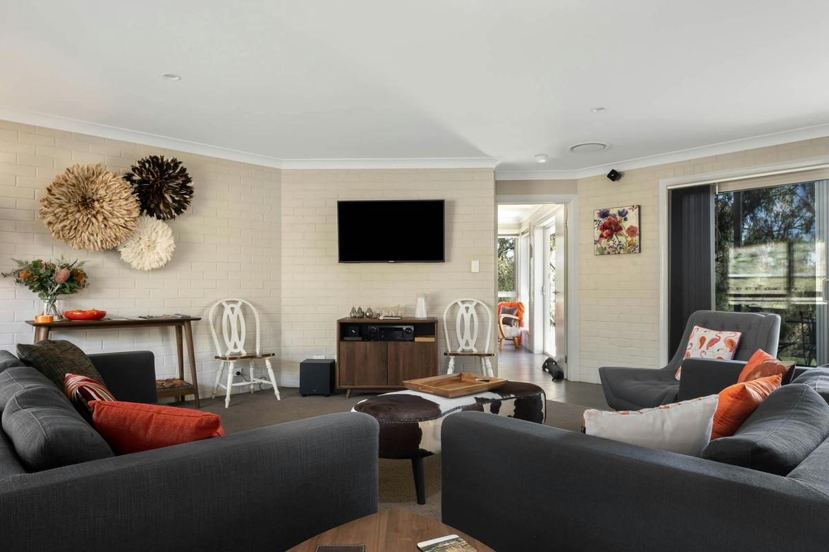 Large lounge area with beautiful decor, TV and large sliding doors onto patio