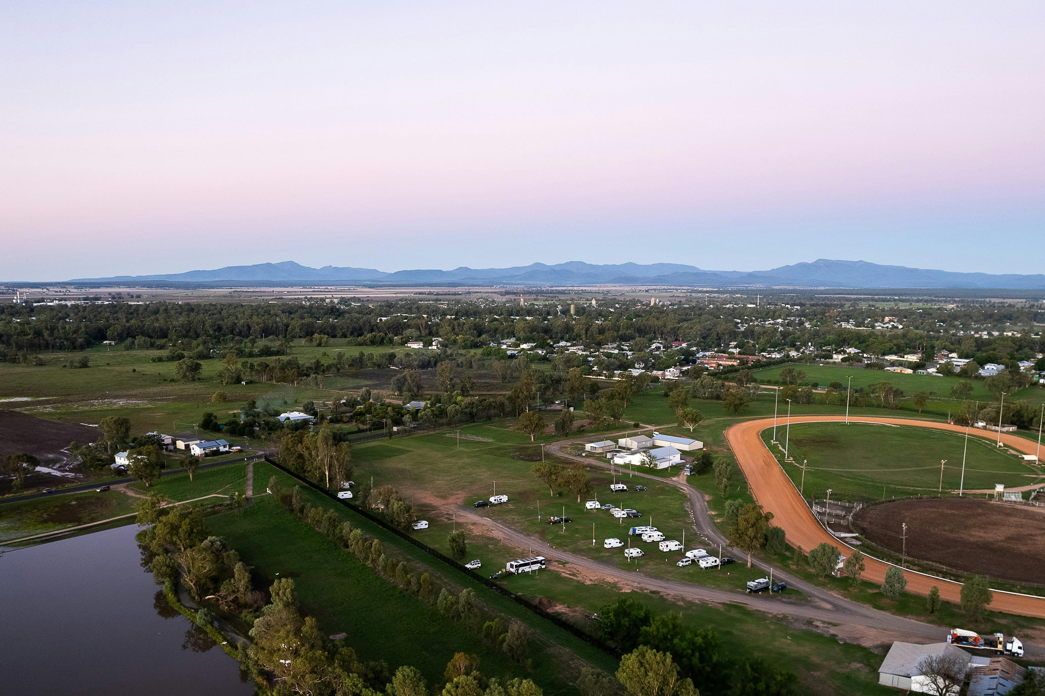 Aerial view of showground at sunset with mountian views