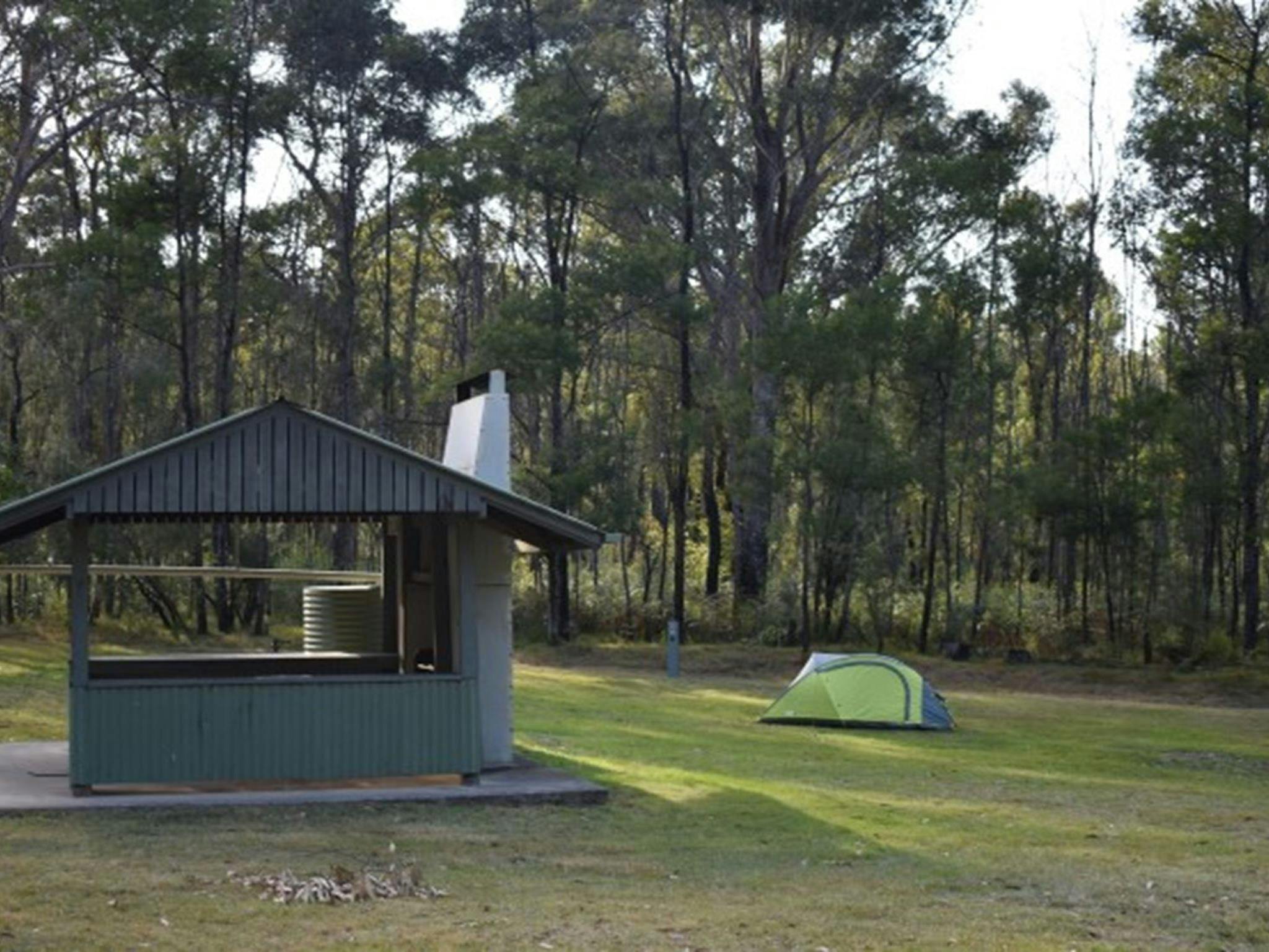 A picnic shelter with a tent in the background at Mogo campground, Yengo National Park. Photo: Sarah