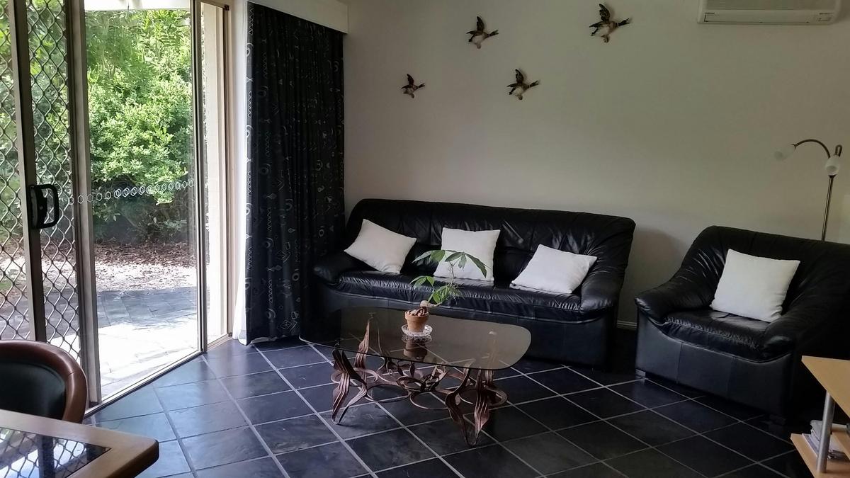 Spacious lounge dining area overlooking gardens with external access to wisteria covered pergola