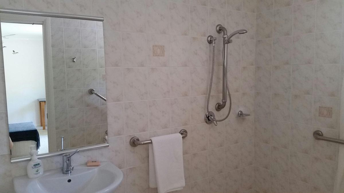 Disabled bathroom with hobless shower, wc adjacent, pedestal basin and bath