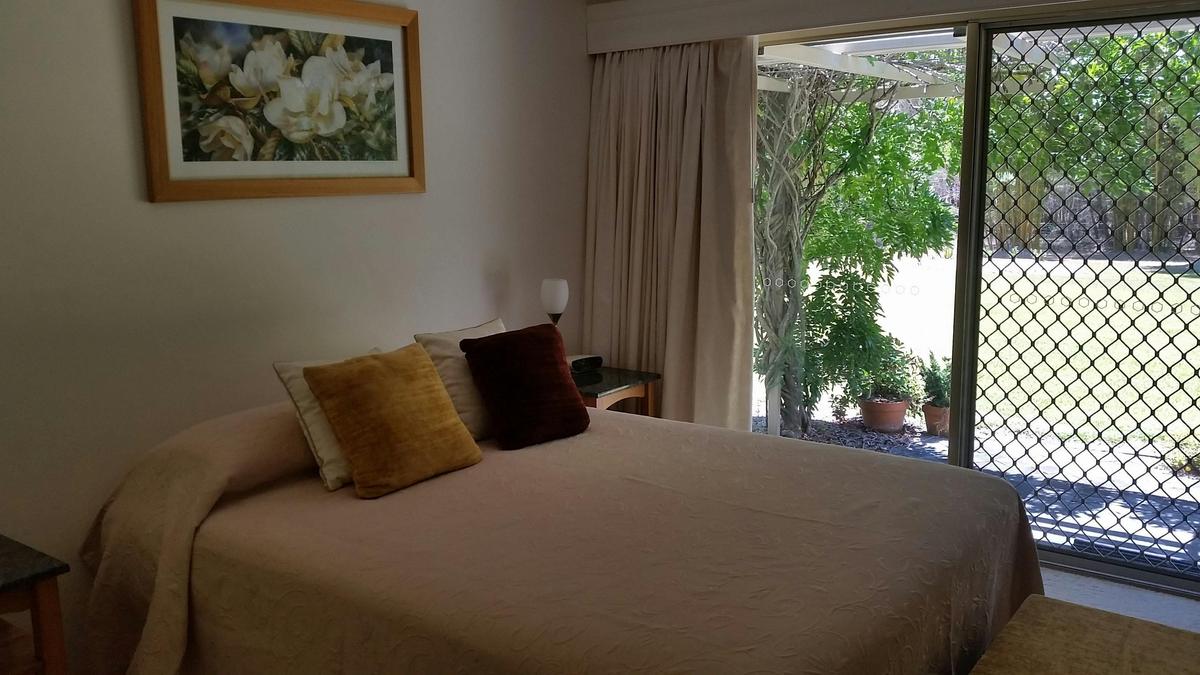 Super comfortable queen size bed in spacious room with exterior access to covered pergola area