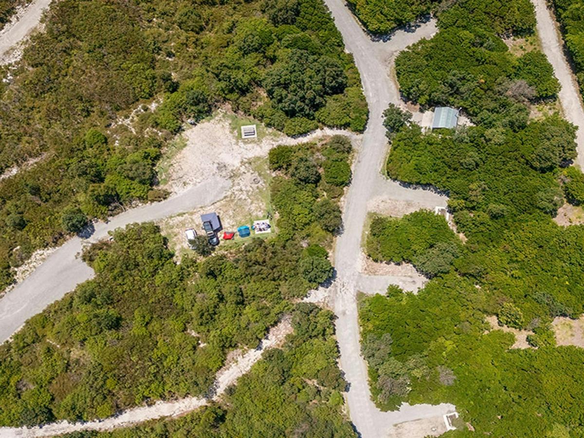 Aerial view of campsites, bushland and the access road at Mibanbah-Black Rocks campground. Credit: