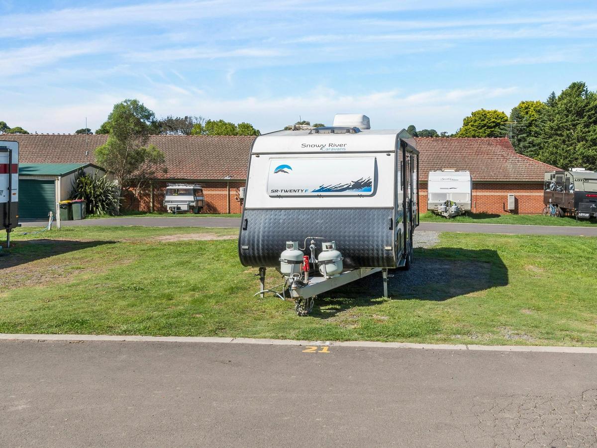 Caravan sitting on large grassed, powered site.