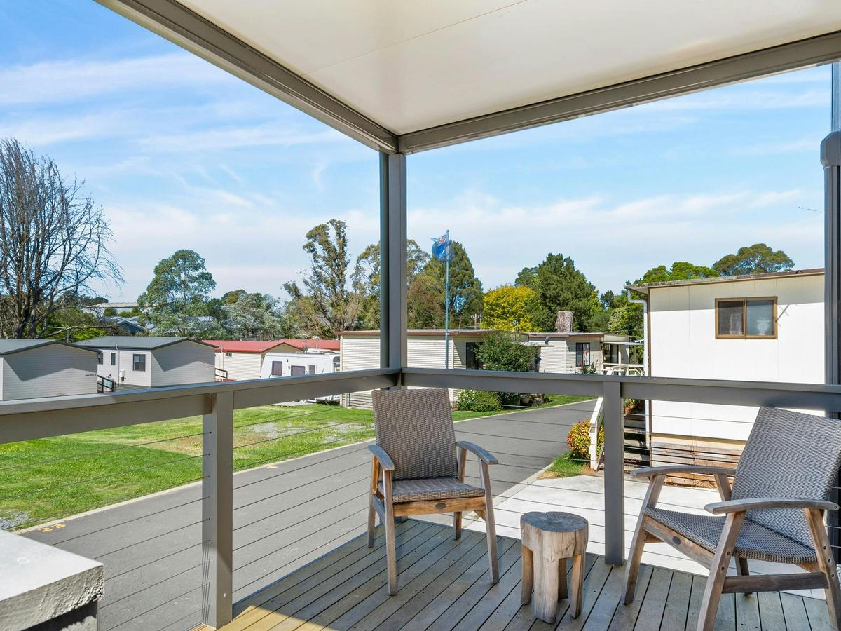 Outlook from cabin deck, overlooking the park, green grass and trees in the background