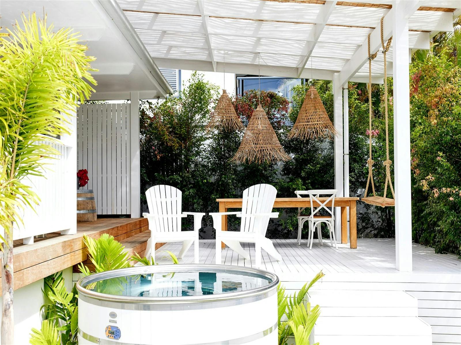 BBQ and entertain outdoors overlooking the white timber hot tub and gated lawns