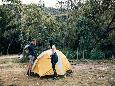 A couple outside their tent at Pretty Beach campground, Murramarang National Park. Photo: Melissa