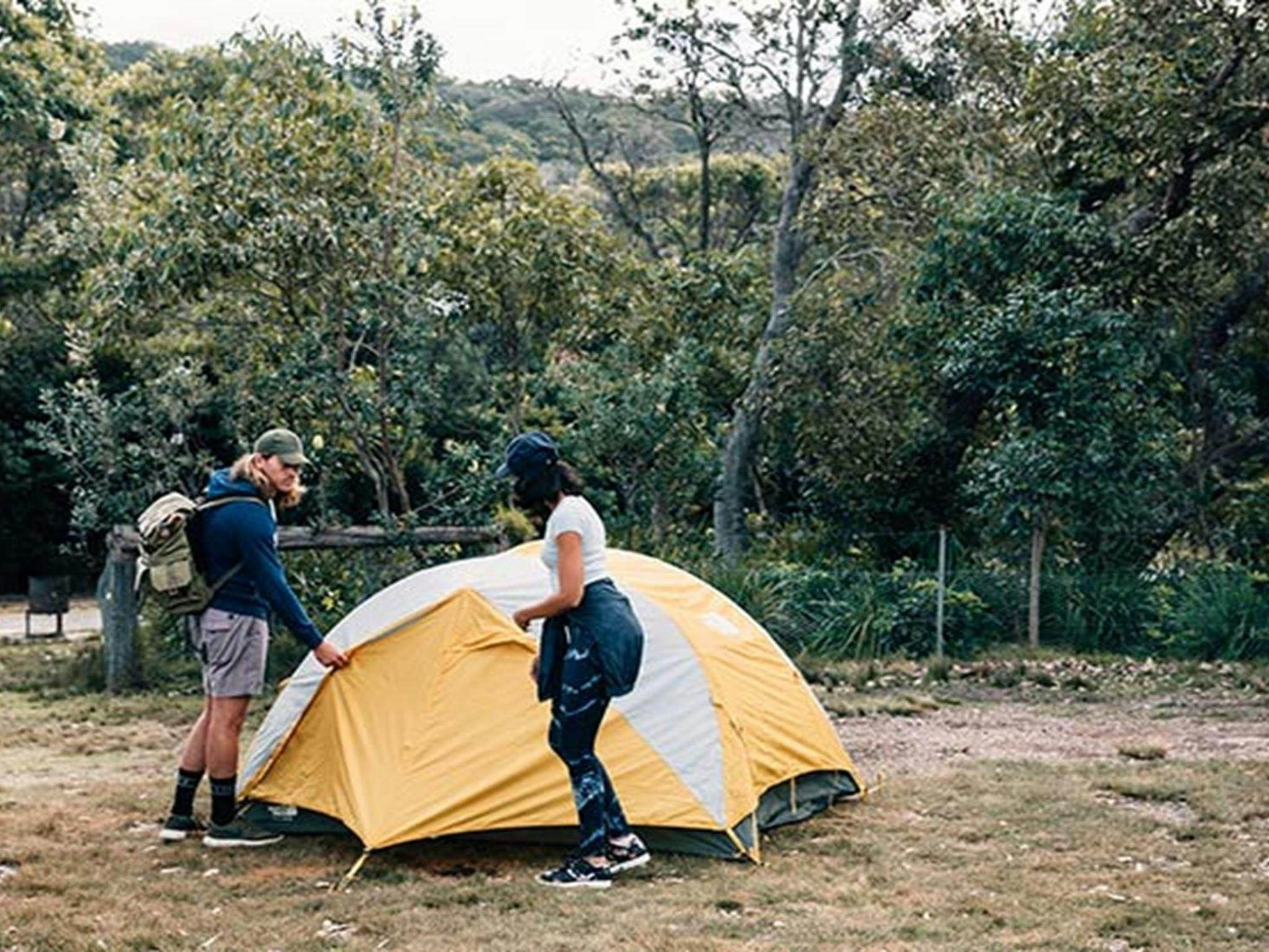 A couple outside their tent at Pretty Beach campground, Murramarang National Park. Photo: Melissa