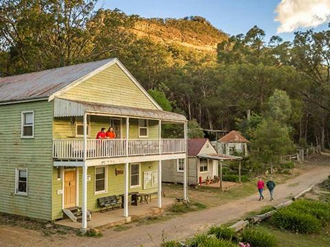 Friends strolling past Post Office Lodge in Yerranderie Private Town, Yerranderie Regional Park.