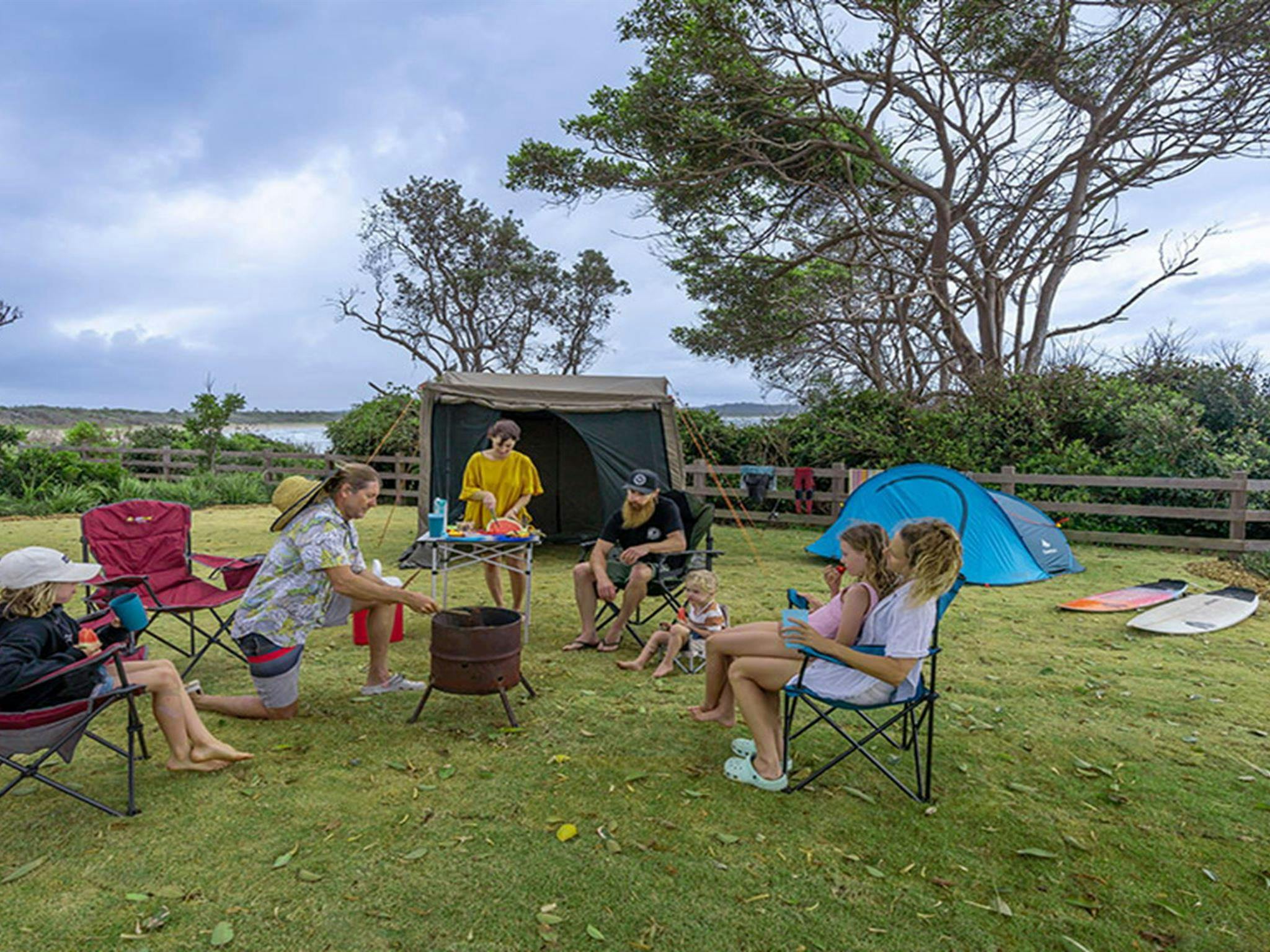 A family camping on a grassy site at Point Plomer campground. Credit: John Spencer &copy; DCCEEW