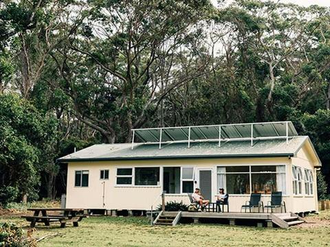 A couple on the deck at Jacks Shack, Pebbly Beach Shacks, Murramarang National Park. Photo: Melissa
