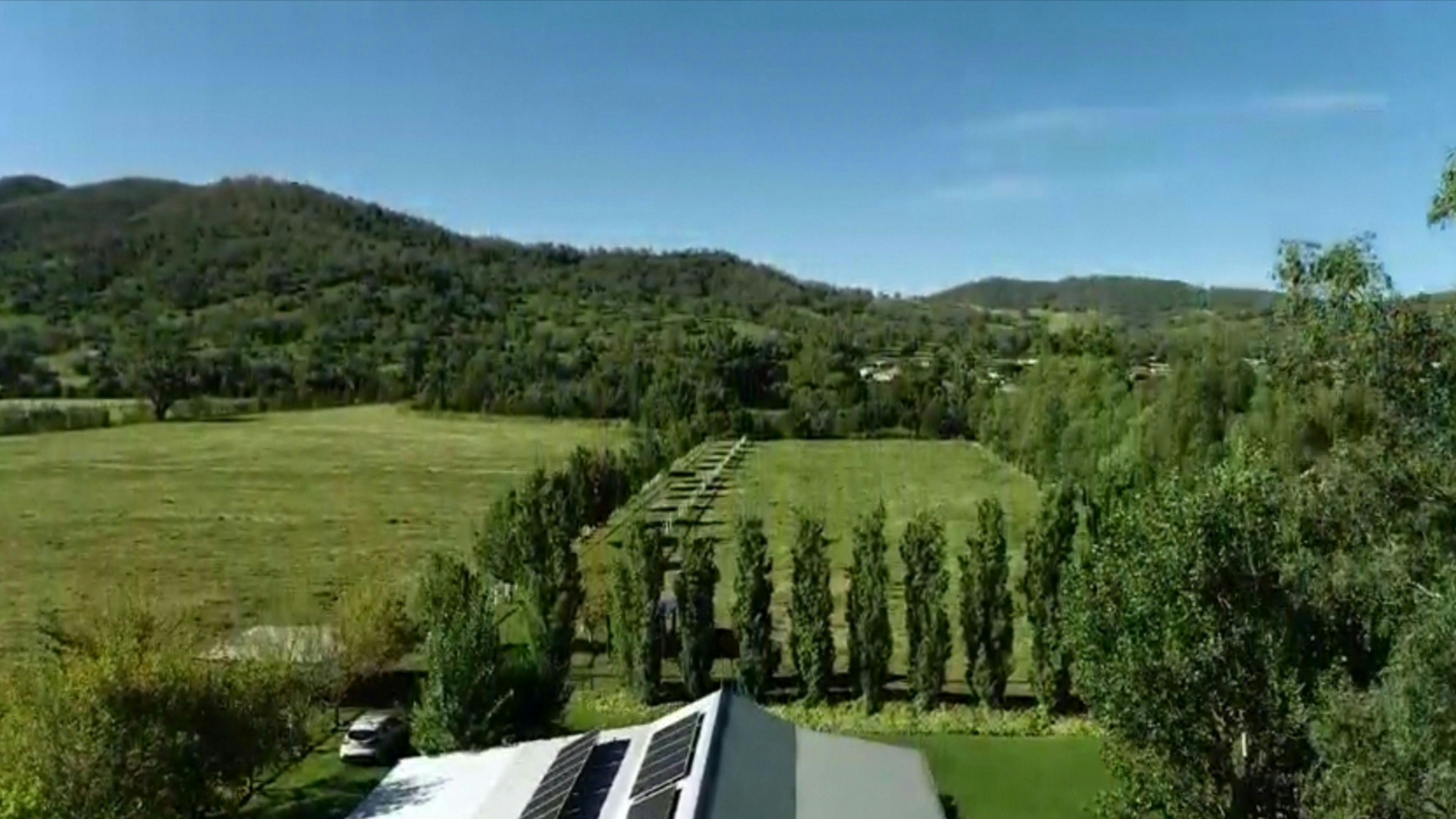 Looking over the stable building and the campsite towards the river and hills in the distance