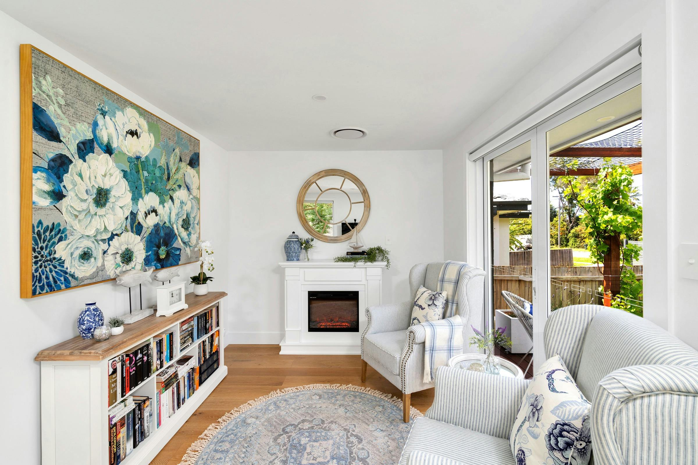 Indoor electric fireplace and book library at Queenberry Cottage, Berry
