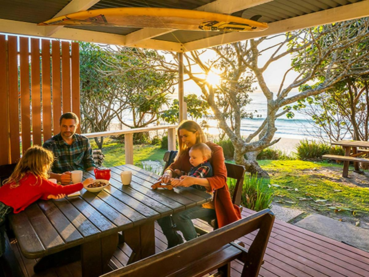 Family on the back deck of Partridge cottage overlooking Byron Bay beach. Photo: DPIE/John Spencer