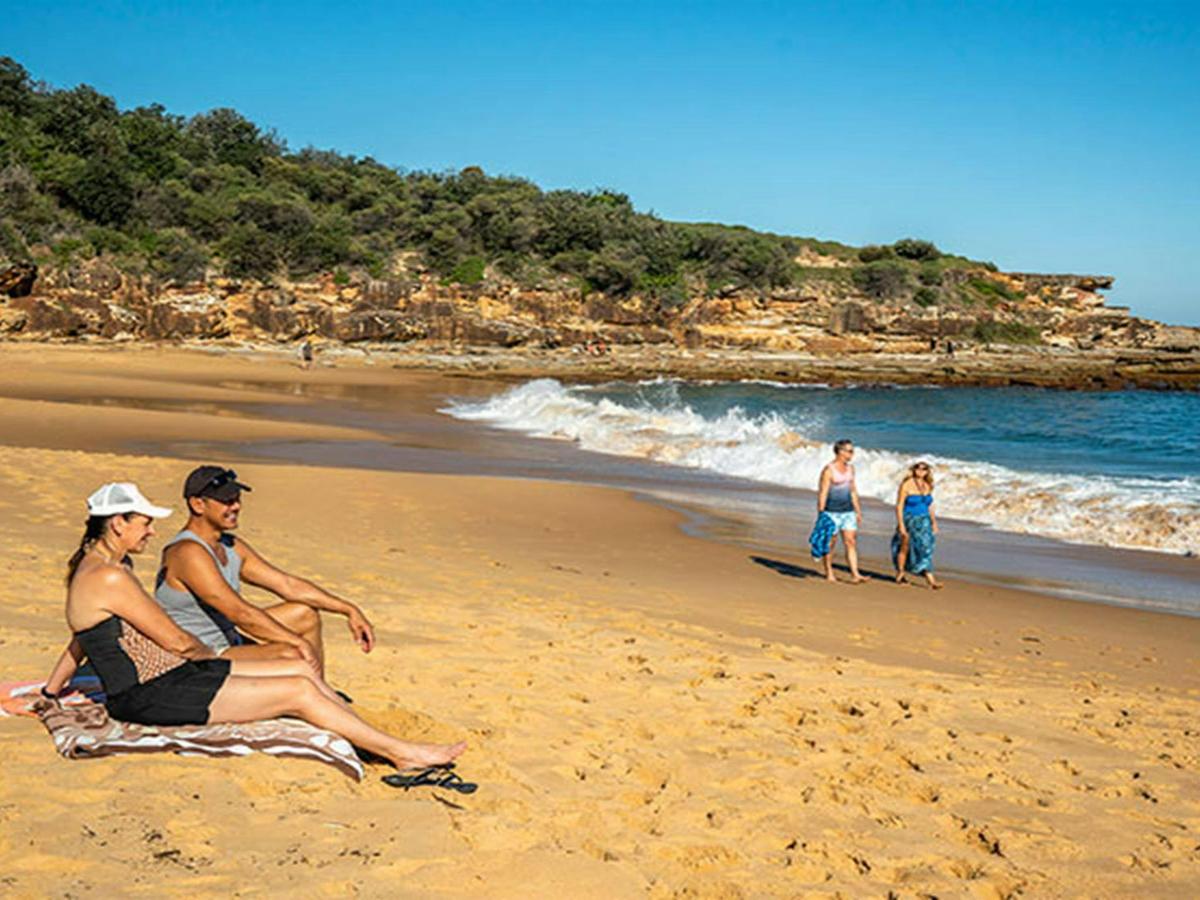 People sunbathing at Putty Beach. Photo: John Spencer/DPIE
