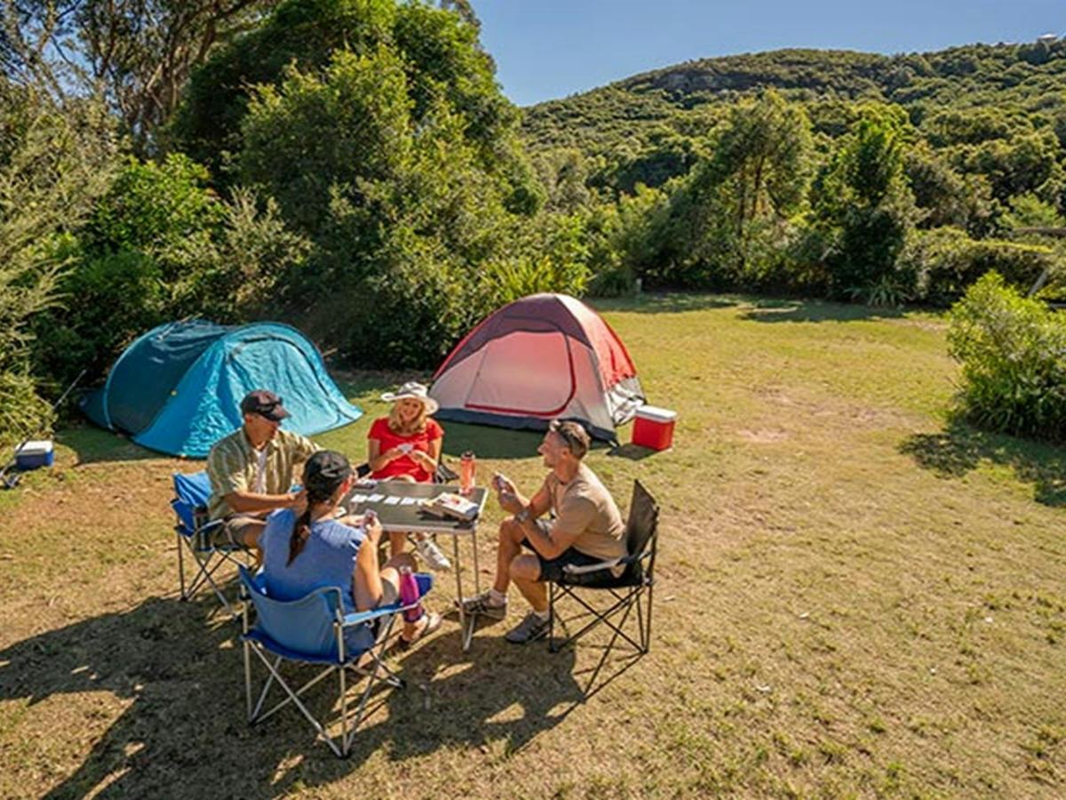 Campers sitting and playing cards at Putty Beach campground. Photo: John Spencer/DPIE