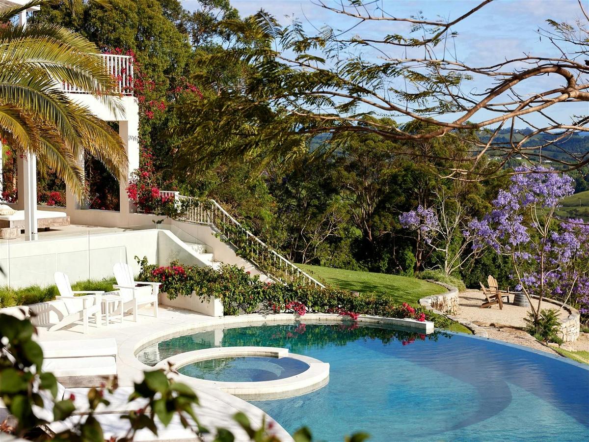 Relaxing pool area with lounge chairs and panoramic greenery views