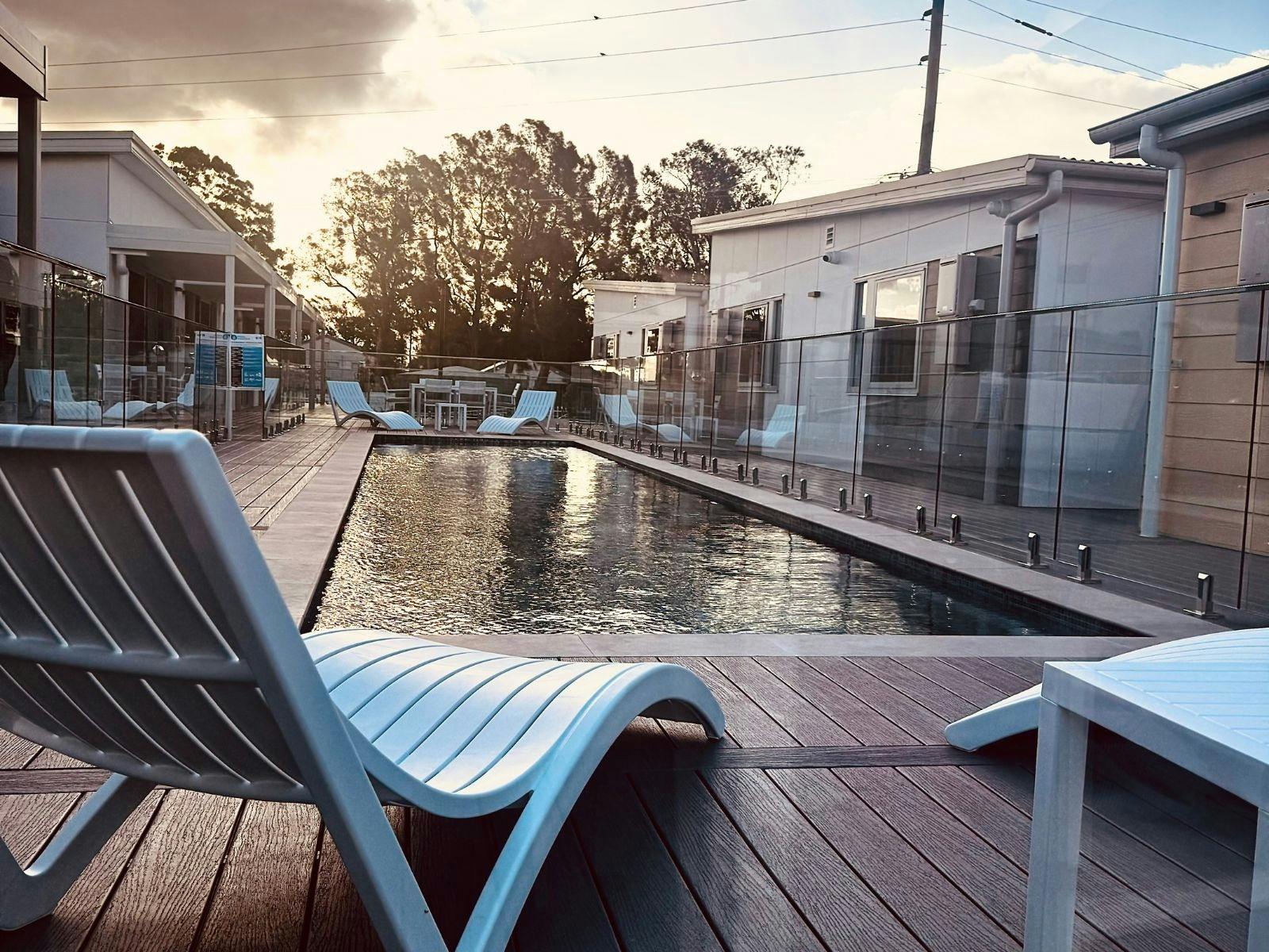 Sun chairs in the enclosed pool area at sunset