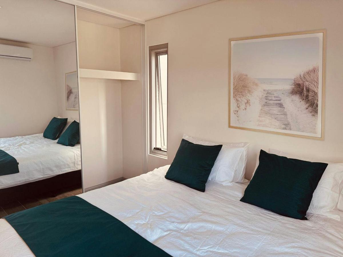 Bedroom with mirrored storage space (2 adjoined king single beds)