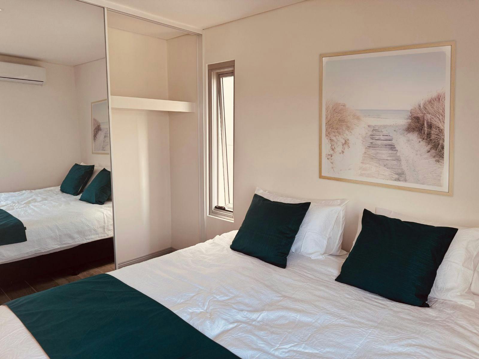 Bedroom with mirrored storage space (2 adjoined king single beds)