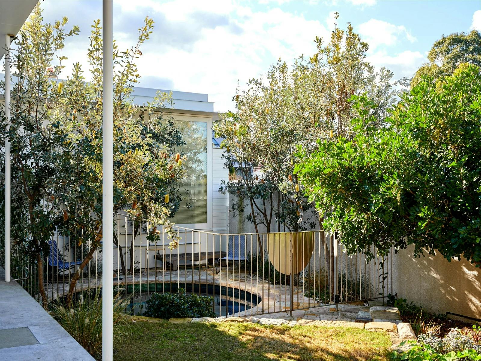 Garden featuring a heated pool and lush landscaping