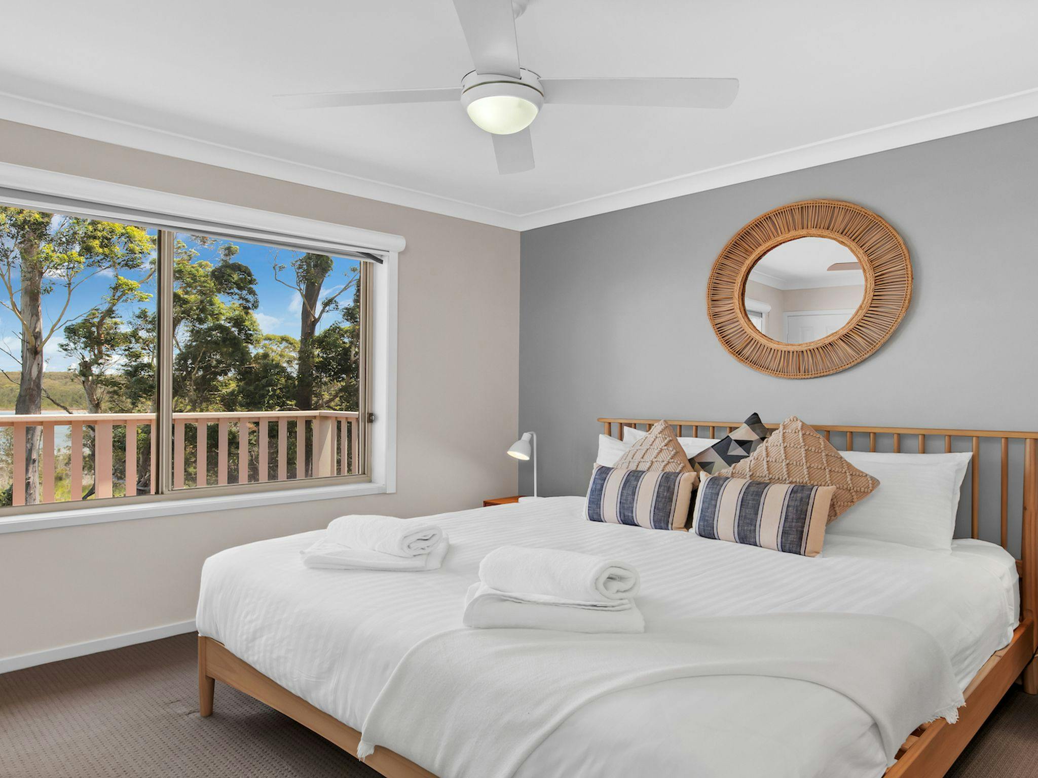 Bedroom with large comfortable bed, ceiling fan and amazing views of lake