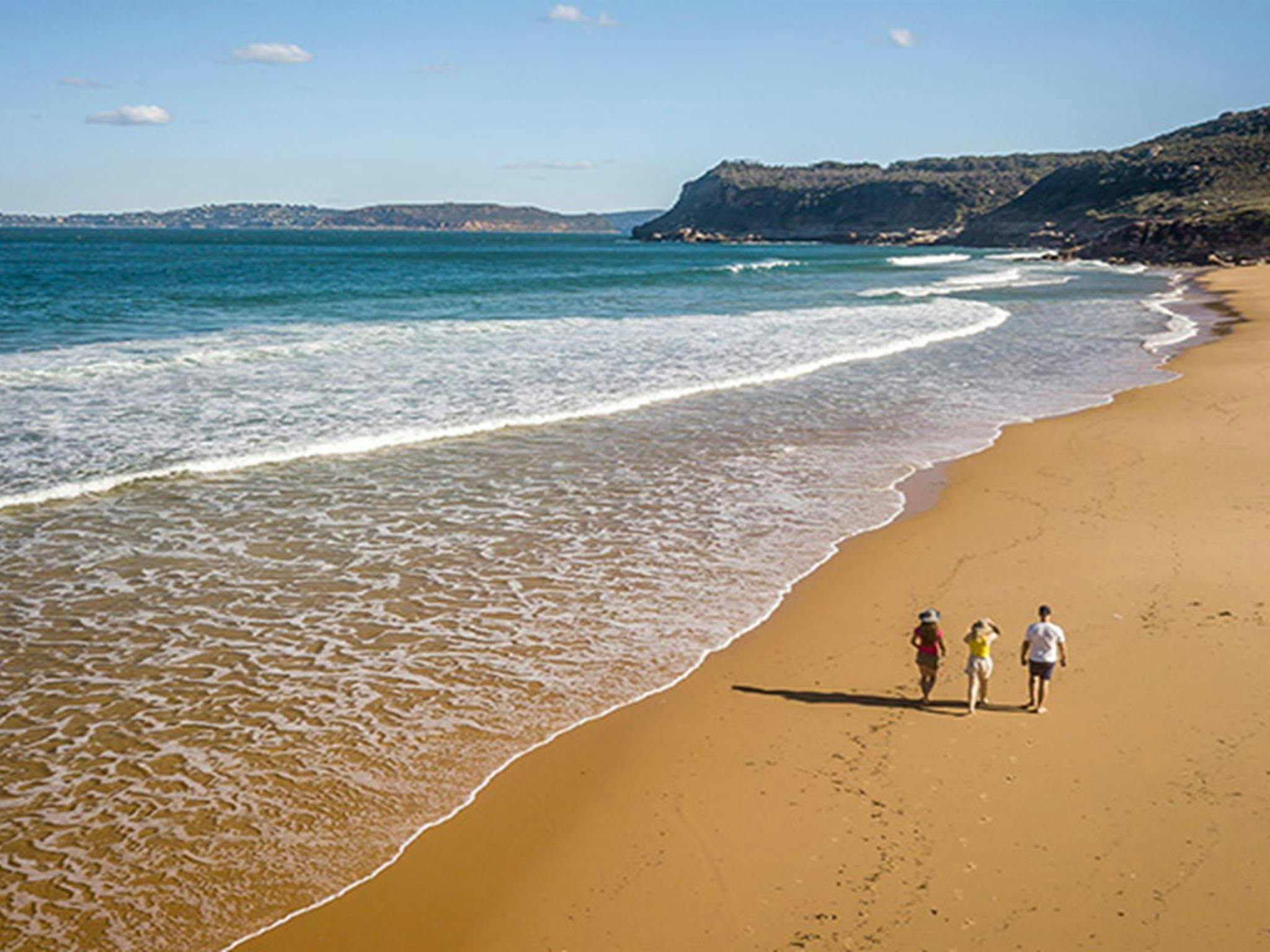 Aerial view of 3 people walking along Tallow Beach, Bouddi National Park. Photo: John Spencer/DPIE.